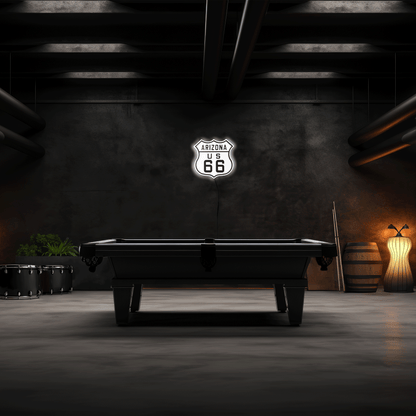 Pool table in a dimly lit room with 'Arizona U.S. 66' sign on the wall.