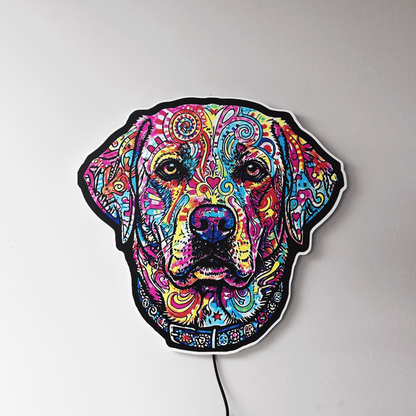 A colorful LED wall light shaped like a English Labrador Retriever head, featuring a vibrant, psychedelic pattern in multiple bright colors on a black base, mounted on a plain light gray wall.