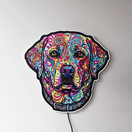 A colorful LED wall light shaped like a English Labrador Retriever head, featuring a vibrant, psychedelic pattern in multiple bright colors on a black base, mounted on a plain light gray wall.