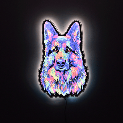 A glowing LED neon sign shaped like a German Shepherd dog face, featuring a vibrant multicolor neon pattern of pink, blue, purple, and yellow on a black backing, set against a dark background.