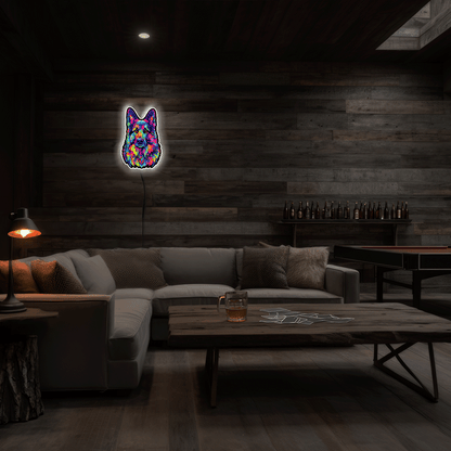 A colorful neon-style wall light shaped like a German Shepherd face hangs on a dark wood-paneled wall in a dimly lit living room with a sectional sofa, coffee table, and lamps.