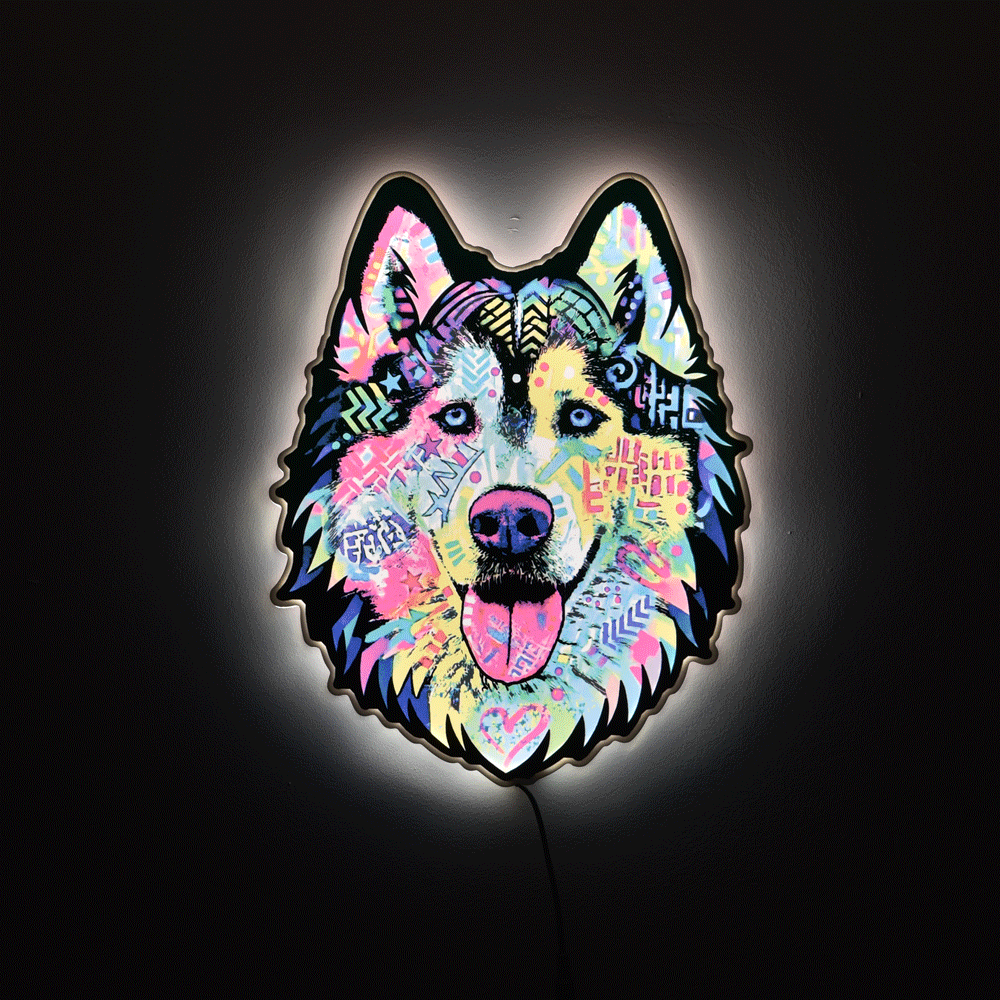 A colorful LED light sign shaped like a wolf or husky head, featuring a vibrant multicolor pattern with pink, blue, yellow, and purple tones, glowing against a dark background.