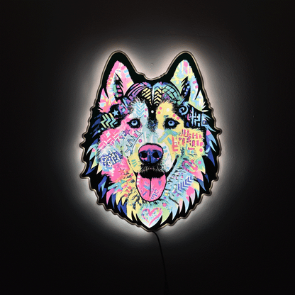 A colorful LED light sign shaped like a wolf or husky head, featuring a vibrant multicolor pattern with pink, blue, yellow, and purple tones, glowing against a dark background.