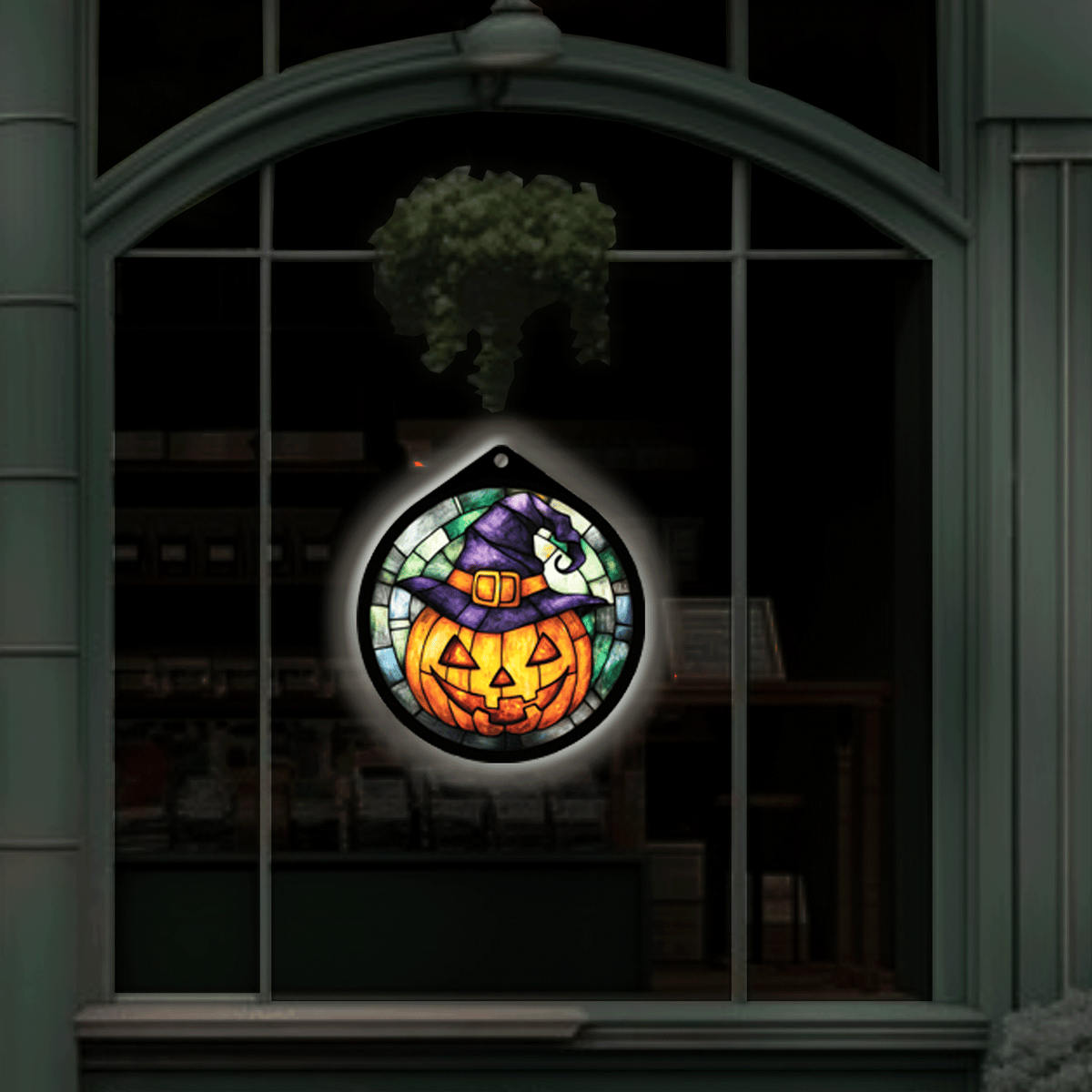 Jack-o'-lantern witch hat LED sign glowing, hanging in a shop window display at night