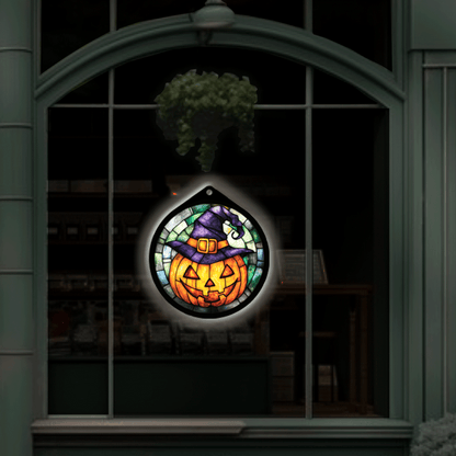 Jack-o'-lantern witch hat LED sign glowing, hanging in a shop window display at night