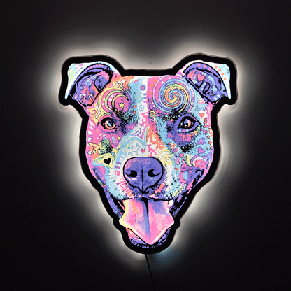 A pop-art style Colorful Smiling Pit Bull Face with tongue hanging out wall light or sign with a black outline, glowing against a dark background. The design features swirling patterns and bright neon-like colors including pink, purple, blue, yellow, and orange.