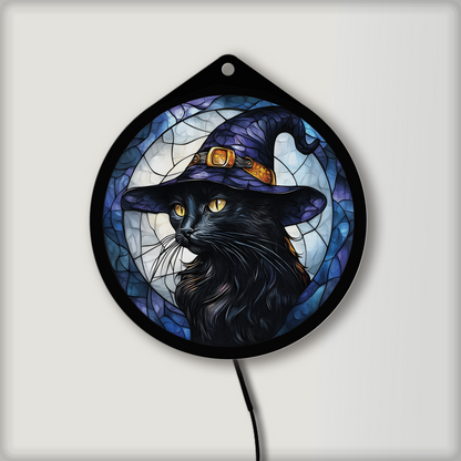 Black cat witch hat LED sign glowing on a wall in a lit room