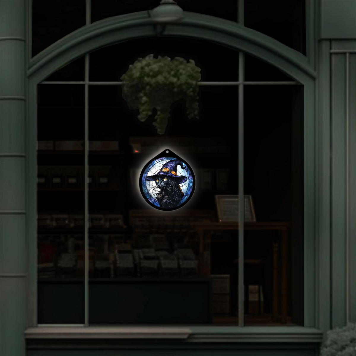 Black cat witch hat LED sign displayed hanging in a shop window at night glowing