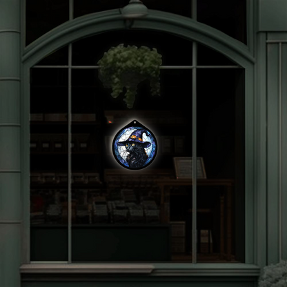 Black cat witch hat LED sign displayed hanging in a shop window at night glowing