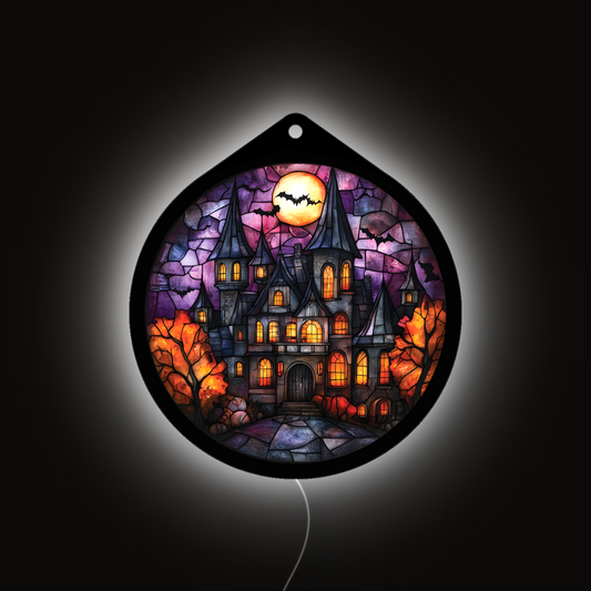 Haunted manor LED sign glowing brightly against a dark background