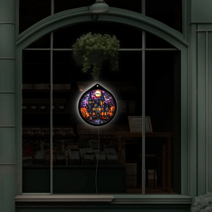 Haunted manor LED sign glowing, hanging in a shop window display at night
