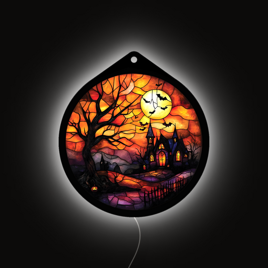 Haunted tree and moon LED sign glowing brightly against a dark background