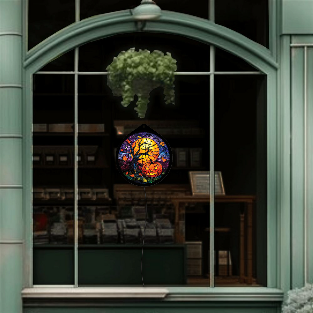 Pumpkin harvest moon LED sign glowing, hanging in a shop window display during the day