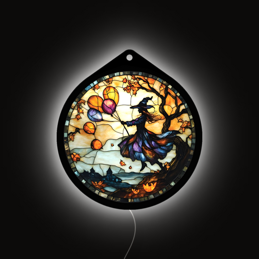 Flying witch with balloons LED sign glowing brightly against a dark background