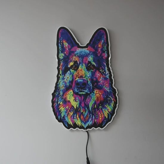 A colorful LED neon-style wall light  turned on and off shaped like a German Shepherd dog face, glowing with a multicolor neon pattern against a plain gray wall. 