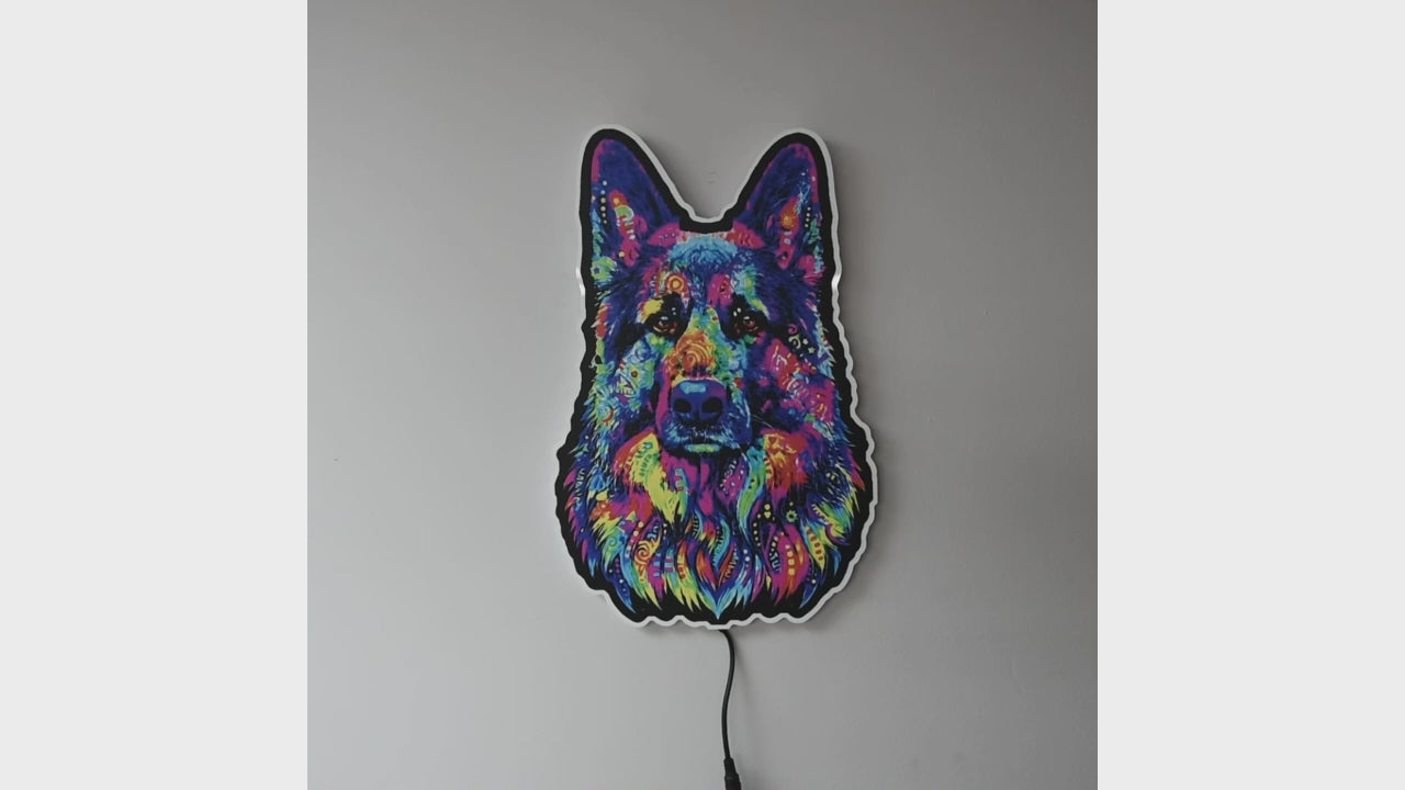 A colorful LED neon-style wall light  turned on and off shaped like a German Shepherd dog face, glowing with a multicolor neon pattern against a plain gray wall. 