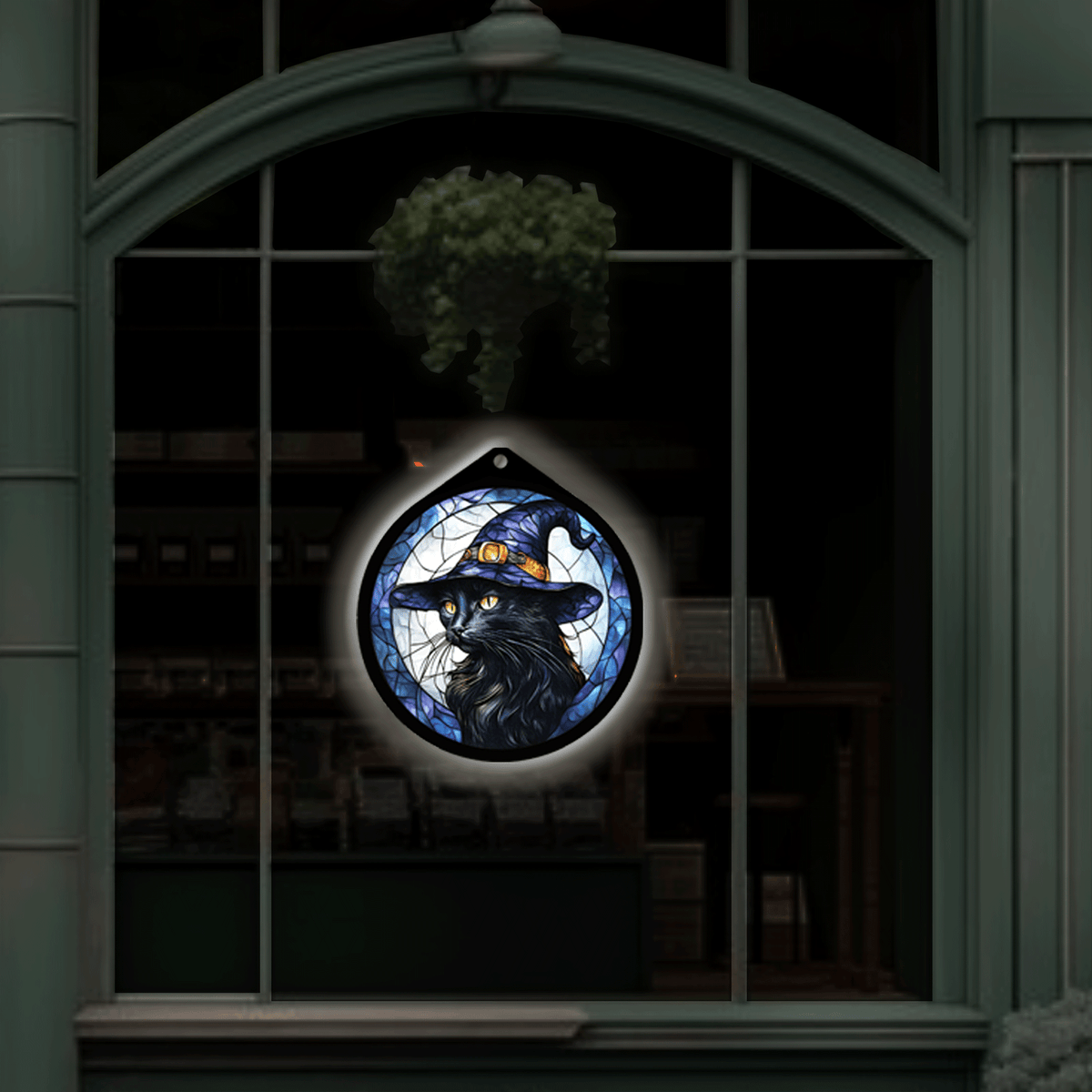 Black cat witch hat LED sign on displayed hanging in a shop window at night