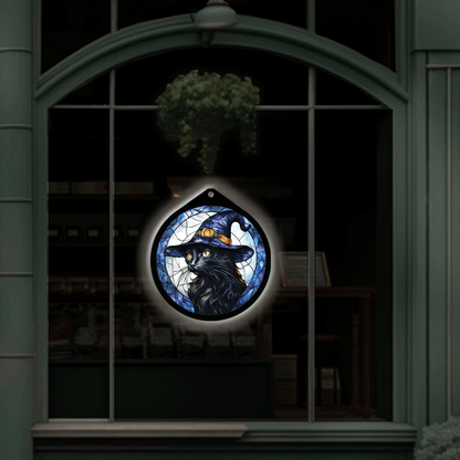 Black cat witch hat LED sign on displayed hanging in a shop window at night